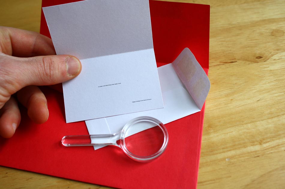 The open card reveals teeny tiny text inside.